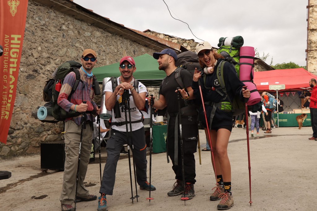 Four friends with backpacks preparing for hiking. Highlander Adventure, Biliki App