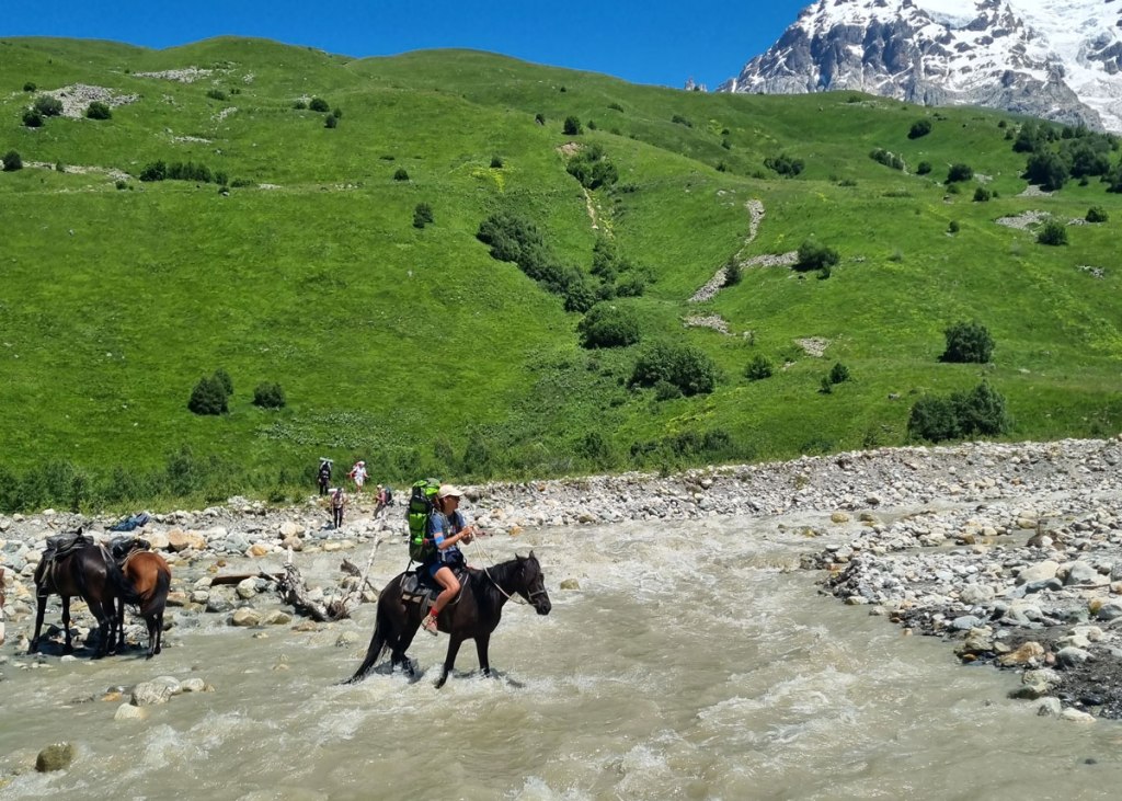 A woman on the horseback crossing the river. Highlander Adventure, Biliki App