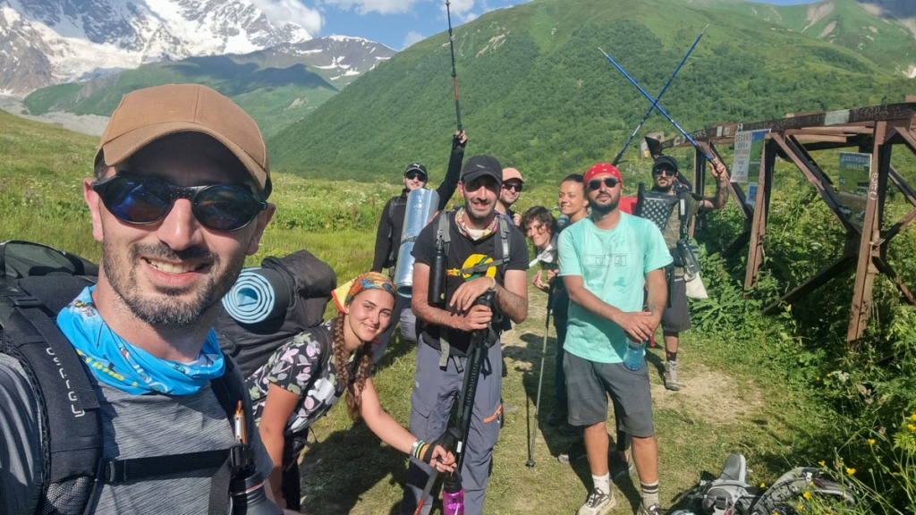 Team of happy hikers smiling and standing in the mountains. Highlander Adventure, Biliki App
