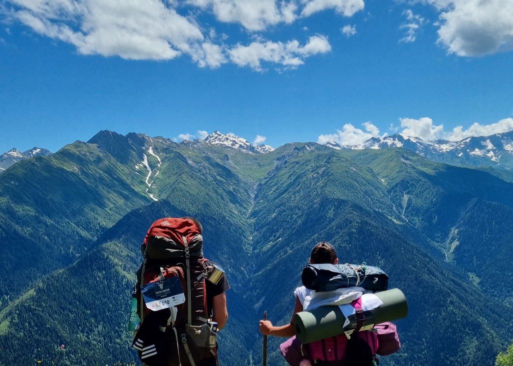 The hiker couple looking at the mountains. Highlander Adventure, Biliki App