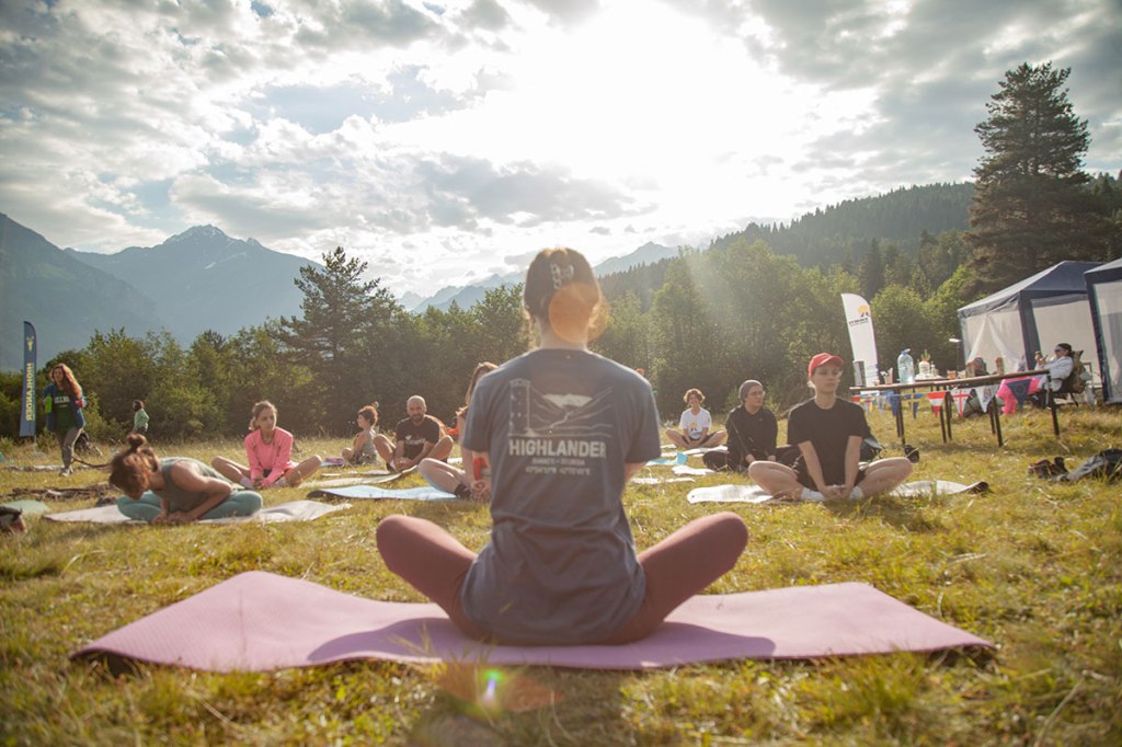 Young people doing morning yoga. Highlander Adventure, Biliki App
